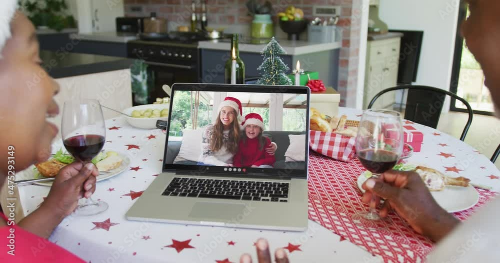 Sticker African american couple with wine using laptop for christmas video call with happy family on screen