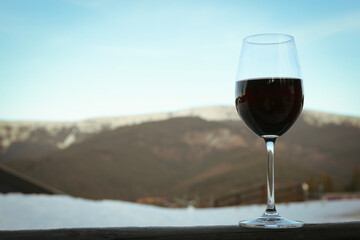 Glass of wine against mountains, space for text
