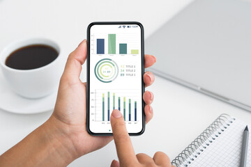 Business analyst holding mobile phone with trading app