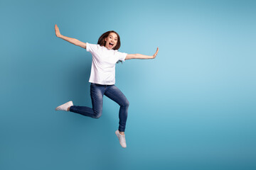 Fototapeta na wymiar Full size photo of young pretty girl enjoy fly arms wings dreamy wear casual clothes isolated over blue color background