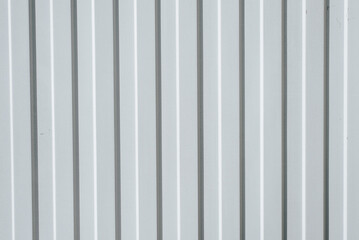 Gray iron construction profiled sheet with vertical stripes. Textured background. Corrugated building material for fences and roofs
