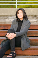 Biracial Asian teen girl sitting on rusty red stairs outdoors