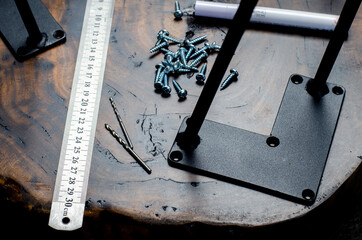 Roulette and pencil. Screws on the table in the workshop. The hands of a wood master. Metal table...