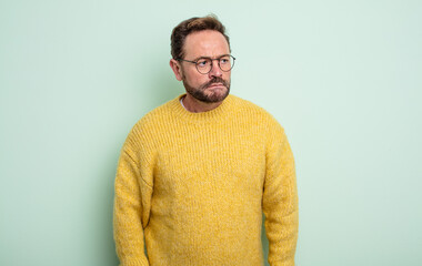 middle age handsome man feeling sad, upset or angry and looking to the side with a negative...