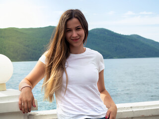 Portrait of a girl on the background of the lake and mountains