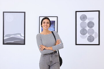 Happy young woman at exhibition in art gallery