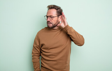 middle age handsome man looking serious and curious, listening, trying to hear a secret...