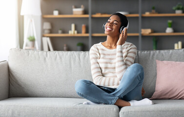 Obraz premium Weekend Relax. Happy Black Woman Listening Audiobook In Wireless Headphones At Home