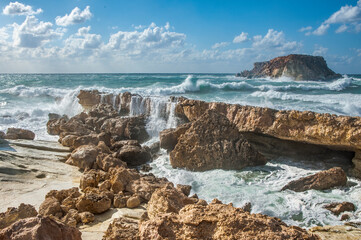 A strong November wind drives roaring waves to the shore, tearing white foam from them. Waves crash against rocky shores, saturating the air with millions of splashes.       
