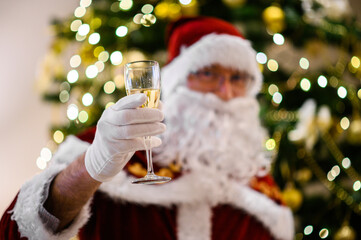 Fototapeta Photo of happy Santa Claus in eyeglasses holding a glass of champagne obraz