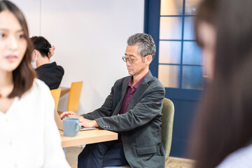 カフェで仕事をする中年男性