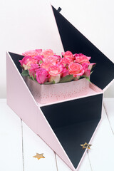 Pink Gift Flower Box with Rose Heart Bouquet, on white wooden background.