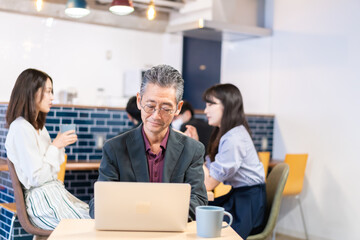 カフェで仕事をする中年男性