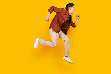 Fototapeta na wymiar Full body profile side photo of young man jump run rush look empty space isolated over yellow color background