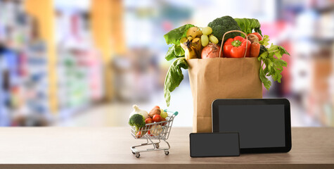 Online shopping background with devices and shopping bag in supermarket