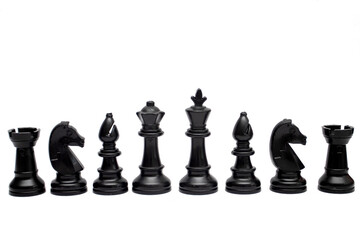 Set of black chess pieces are lined up isolated on a white background