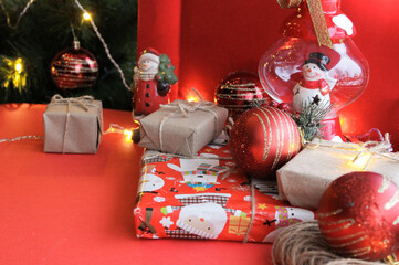 Christmas composition of gift in kraft paper on bright red background. Flat plan, top view, top lay, lay out, flat lay, top view, copy space. Christmas, winter, new year concept. Space for text