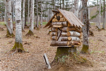 a dollhouse made of logs. A miniature hut in the forest.