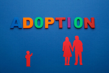 Figures of parents with child and word Adoption on blue background, flat lay