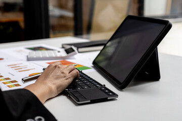 Hands of business woman typing on a tablet keyboard, she is using a messaging program to talk to a business partner who is opening a startup company. Concept of using technology in communication.