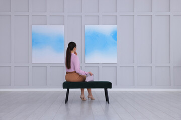 Young woman at exhibition in art gallery, back view - Powered by Adobe
