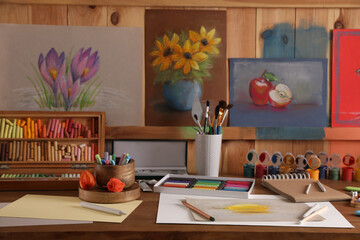 Artist's workplace with drawing, soft pastels and color pencils on table