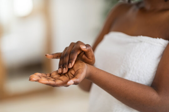 Cropped View Of Young Black Woman Applying Moisturizing Hand Cream At Home, Closeup