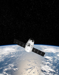 Cargo space craft and Earth planet. Dark background. Sci-fi wallpaper.Space Station Orbiting Earth.Space ship. Space art wallpaper.Solar Observatory.Elements of this image furnished by NASA.