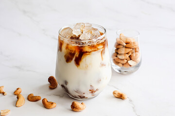 Close up homemade iced latte with plant base milk cashew nut milk with cashew nuts decorated on...