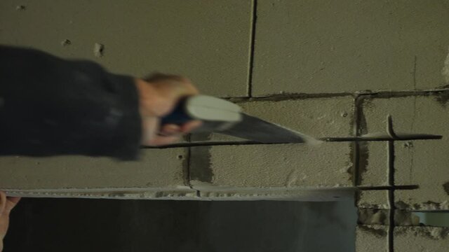Time-lapse footage of a man's hand sawing a doorway out of foam block with a hand saw. Close-up. The concept of room renovation