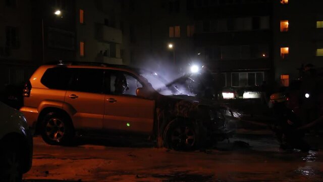 The fire brigade extinguishes a burning car at night.Arson of the car.