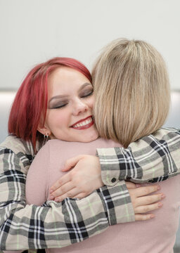 Happy teenage daughter hugs her mom at home