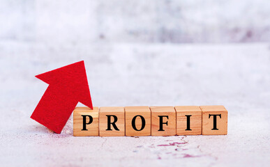 Profit word  written on wooden cubes with red up arrow .Business concept