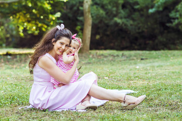 Fototapeta premium Happy Mother with her Baby Girl in the Summer Park .Mother and Daughter .Happy Family, Mother with Little Child