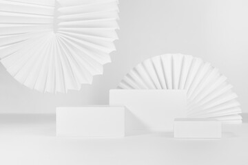 Set of three white rectangle podiums mockup for presentation, showing, displaying cosmetic product or goods with ribbed paper fans, blinds in elegant minimalistic modern style, front view.
