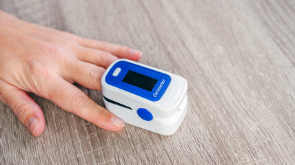 Home pulse oximeter, patient measuring the blood oxygen with oximeter