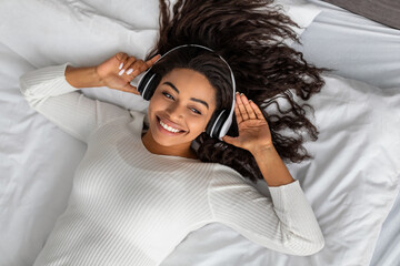 Satisfied young black woman listening to music