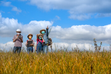 Fototapeta na wymiar Children and mother learning and playing on grassland on blue sky background