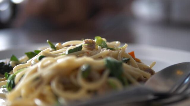 Pasta with Cheese Plate Sitting on a Table and Parmesan is Falling on Basil and Spaghetti in Slow Motion 4K