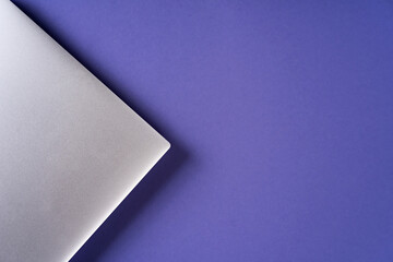 Silver person using a laptop computer on purple trendy paper background. Background in trendy purple color. Demonstrating color of 2022 year