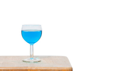 Blue Hawaiian water in a glass set on a wooden stick on a white background.