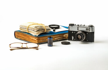 Albums with old family photographs and a camera on a white background. 