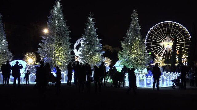 People attend Christmas decorations and coloured water fountains in Nice, France