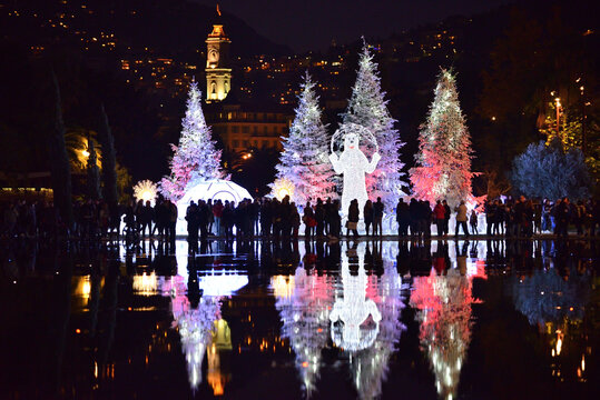 Christmas decorations with snow-covered trees and funfair Ferris wheel. Nice, France