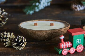 One candle in a coconut shell on the background of a Christmas decor.
