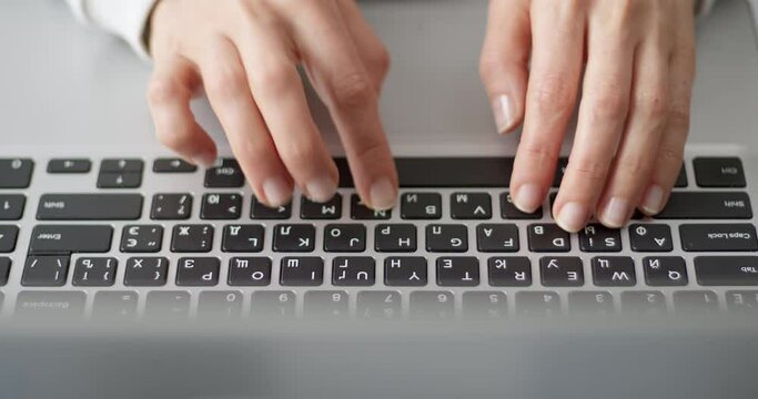 Female fingers are typing text on the laptop keyboard. Business woman works using a computer.