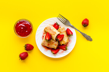 Hot rolled pancakes with strawberry and berry sauce