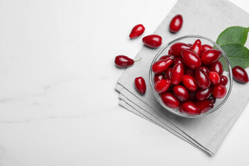 Fresh ripe dogwood berries on white marble table, flat lay. Space for text