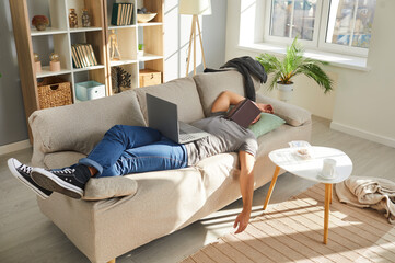 Exhausted guy lying sleeping on sofa overwhelmed with college exam or test preparation study online. Tired man student doze off feel fatigue meet deadline work on computer. Overwork concept.
