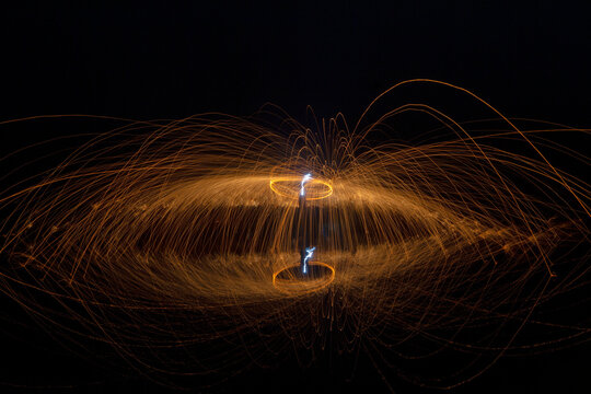 Burning steel wool, reflection in water, fireworks